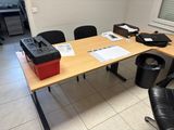 a desk with a printer, printer case, and other office supplies on it