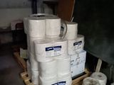 several rolls of toilet paper are stacked on a pallet in a garage