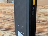 une photo d'une batterie externe noire posée sur une table en bois