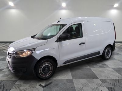 La camionnette blanche est garée dans une grande pièce au sol carrelé en damier.