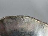a silver bowl with a handle on a table