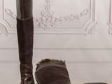 pair of brown boots on a wooden floor next to a wall