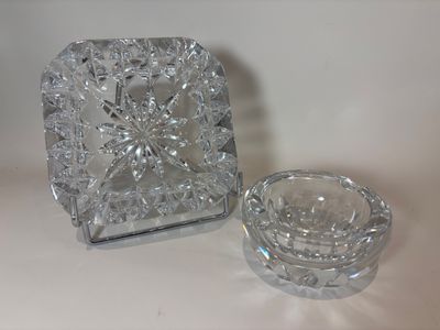 a glass ashtray and a glass ashtray sitting on a table