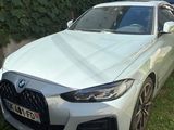 La BMW blanche est garée devant une maison.