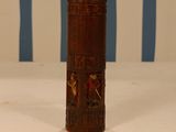 a small wooden cylinder with carvings on it on a table