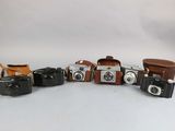 several cameras are lined up in a row on a white surface