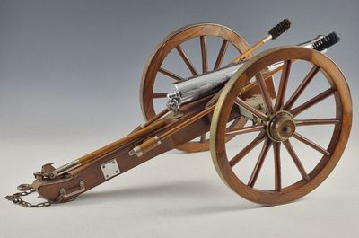 un petit canon en bois auquel est attachée une longue chaîne