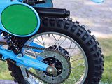 a blue dirt bike parked on the side of the road