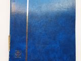 une image représentant un cahier bleu posé sur une table blanche
