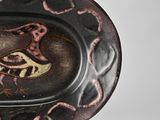 a decorative plate with a bird on it on a table