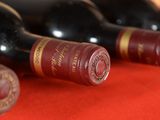 several bottles of wine are lined up on a red table
