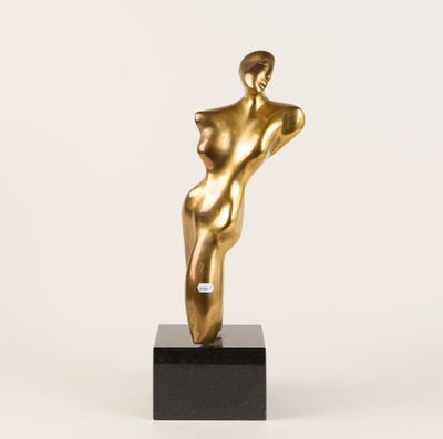 une statue en or représentant une femme debout sur un socle noir