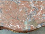 a table with a marble top sitting on a tile floor