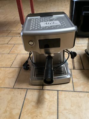 une photo d'une machine à café posée sur un sol carrelé