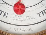 a close up of a clock with a red wax seal on it
