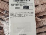 a tag on a pile of sweaters that are wrapped in plastic