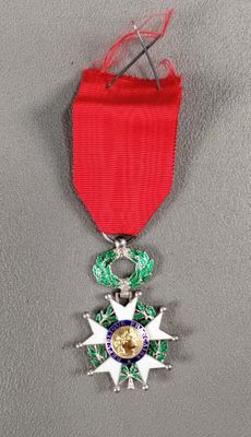 la médaille est accrochée à un ruban rouge orné d'une étoile