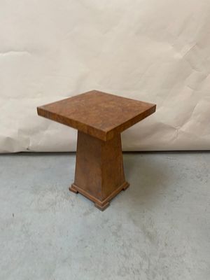 une photo d'une petite table en bois posée sur un sol en béton