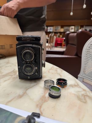 a man standing next to a table with a camera on it