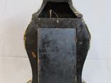 a small clock that is sitting on a stand