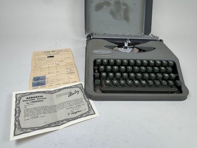 une vieille machine à écrire posée à côté d'un vieux document