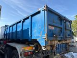 a blue dump truck that is parked on the side of the road