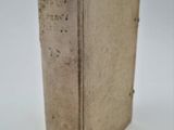 an old book sitting on top of a table on a white surface