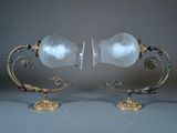 pair of antique brass and glass lamps on stands on a gray background