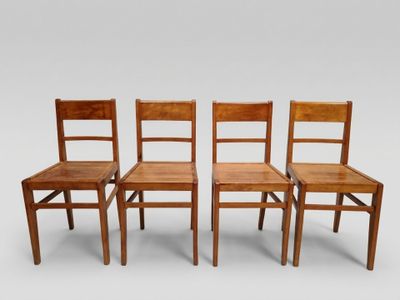 trois chaises en bois assises l'une à côté de l'autre sur une surface blanche