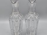 pair of clear glass vases sitting on top of a white surface