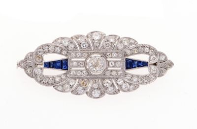 un gros plan d'une broche ornée de diamants et de saphirs