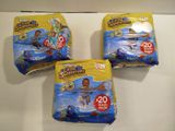 three packs of diapers sitting on top of a white counter