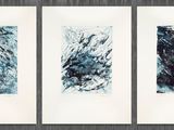 three paintings of blue and black ink on white paper hanging on a wall