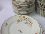 many plates and cups on a table with a white table cloth