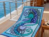a towel on the deck of a boat that has a seahorse on it