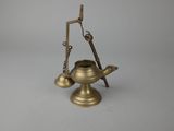 an old brass oil lamp with a stick on top of it