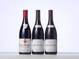 three bottles of red wine are lined up on a table