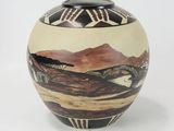 a vase with a picture of a mountain scene on it