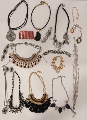 many different necklaces and bracelets displayed on a white surface