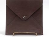une enveloppe marron avec une poignée métallique sur fond blanc