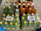 many bottles of juice sitting on a table in a store