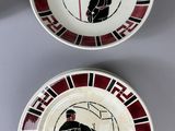 pair of red and white plates with black and white designs on them