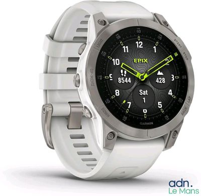 une montre connectée avec un bracelet blanc posée sur une surface blanche