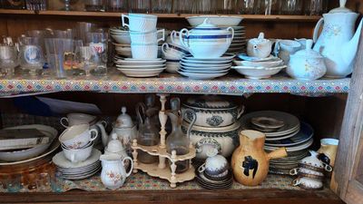 de nombreuses assiettes et tasses rangées sur une étagère dans un placard