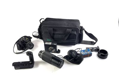 un appareil photo, un sac pour appareil photo, un appareil photo et d'autres objets disposés sur une surface blanche