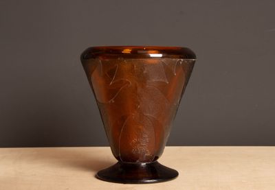a brown glass vase sitting on a wooden table