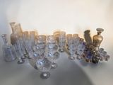 bottles and glasses on a table with a shadow of a person in the background