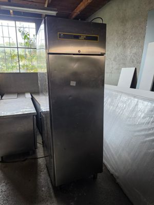 une photo d'un réfrigérateur dans une pièce où se trouve un matelas