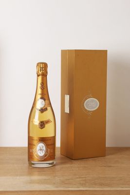 des bouteilles de champagne posées sur une table en bois, à côté d'une boîte marron