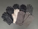 five pairs of leather gloves sitting on top of a table
